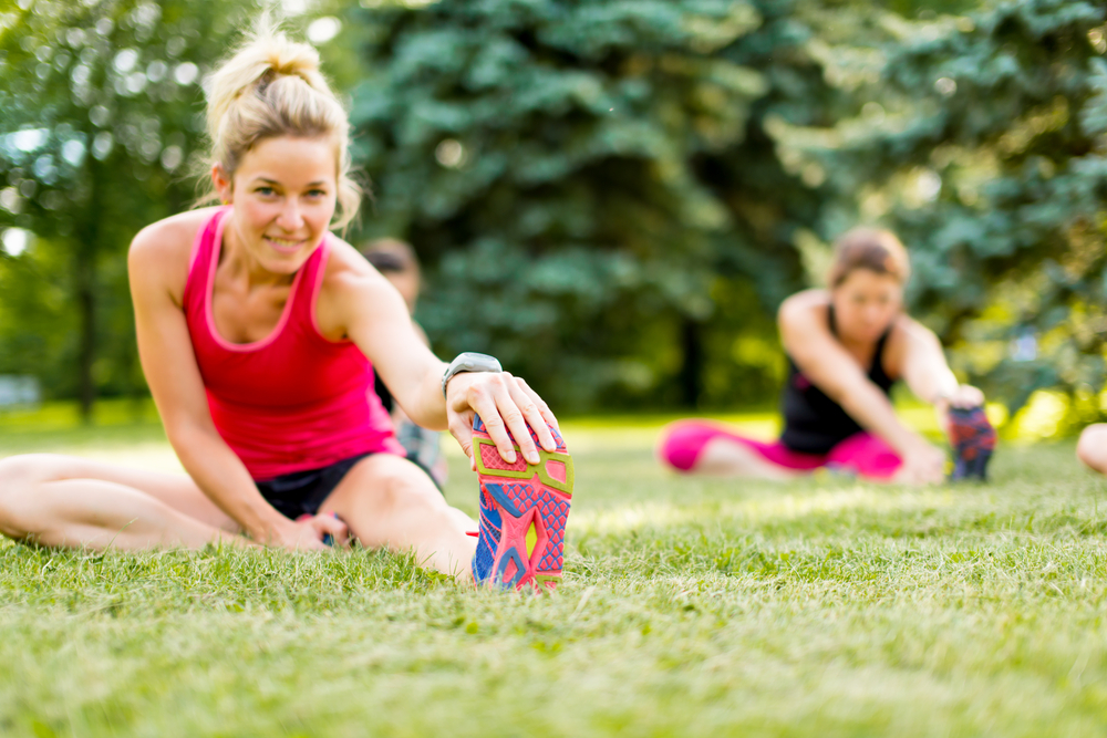 Portait of a blond girl getting streching her legs before running outdoors